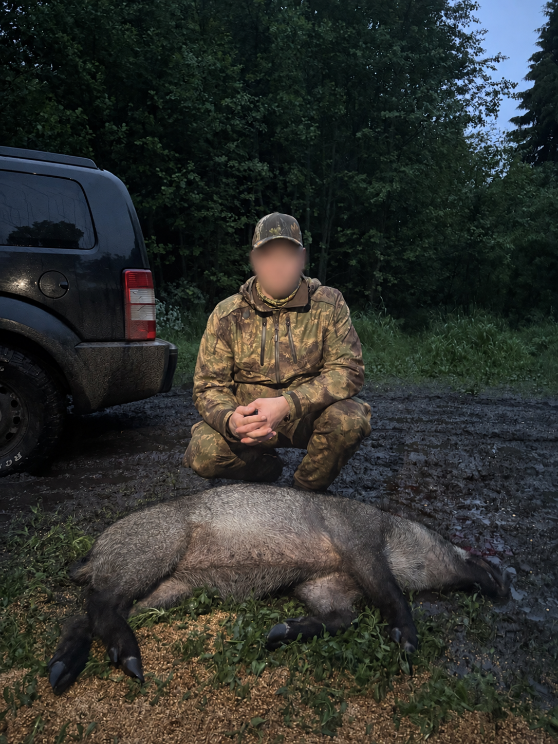 Hunter beside a harvested wild boar